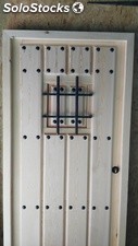 Puerta de madera rústica con ventano y clavos